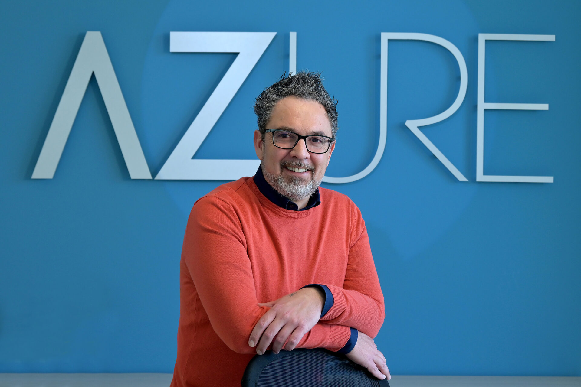 Valerio Marinucci, fondatore di DealerMAX, fotografato davanti al logo AZURE Srl negli uffici di Buccinasco, Milano